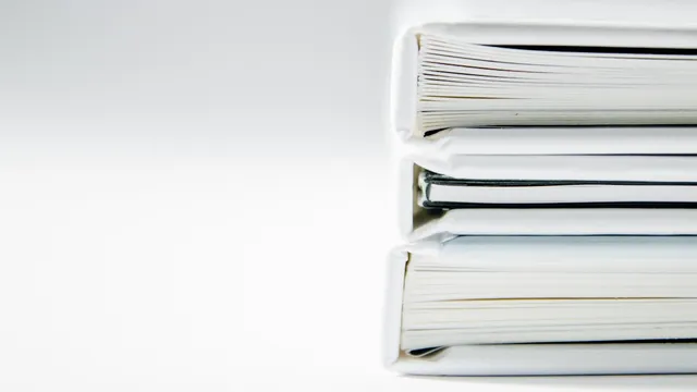 A neat stack of thick document folders on a clean white surface